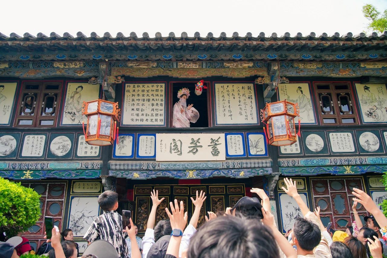 2▲朱家花园“朱小姐”抛绣球与游客互动